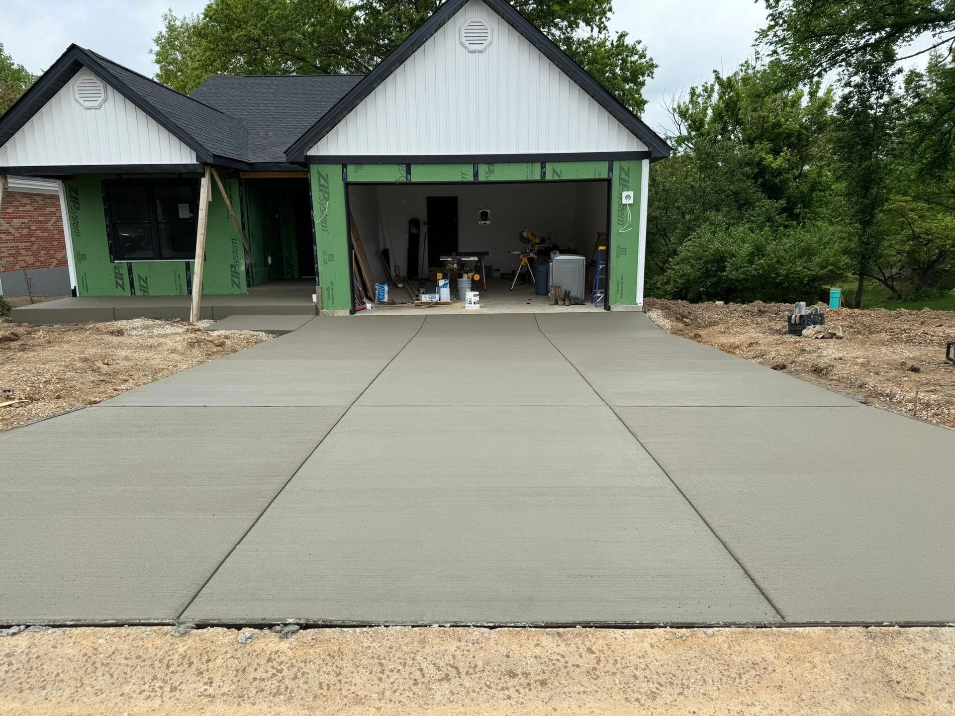 A concrete driveway leading to a house under construction