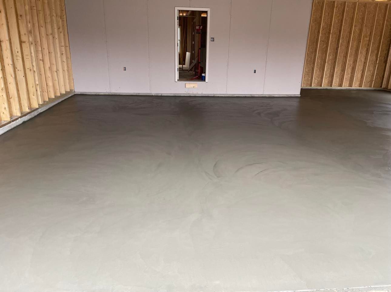 A garage with a concrete floor and wooden walls.