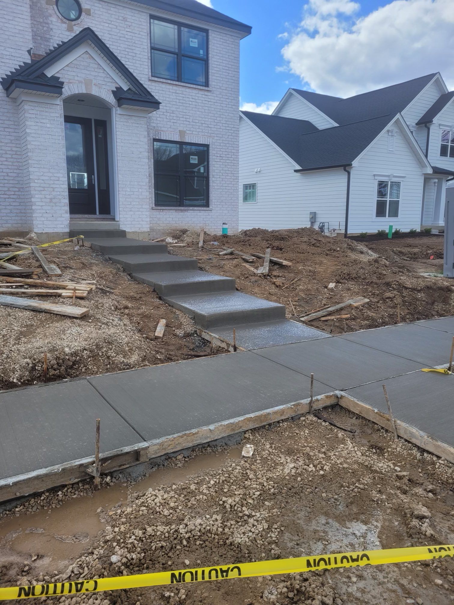 A concrete walkway is being built in front of a house.