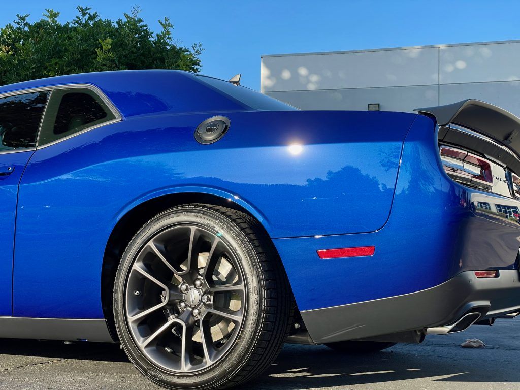 A blue dodge challenger is parked in a parking lot