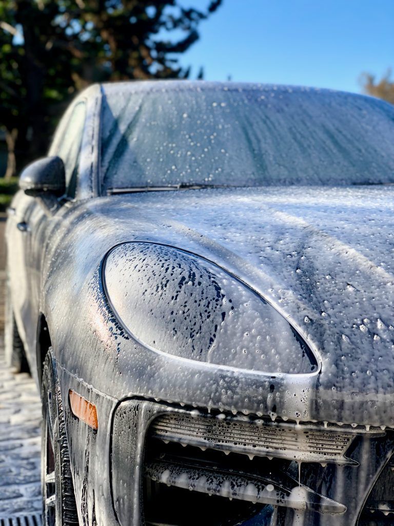 A close up of a car covered in foam.