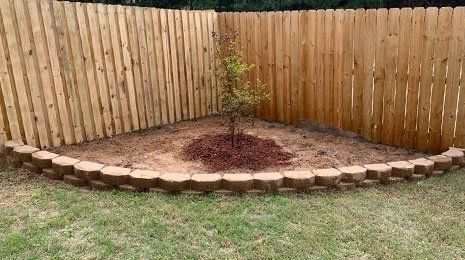Curved Retaining Wall Beside Fence — Tyler, TX — Creative Landscape Solutions