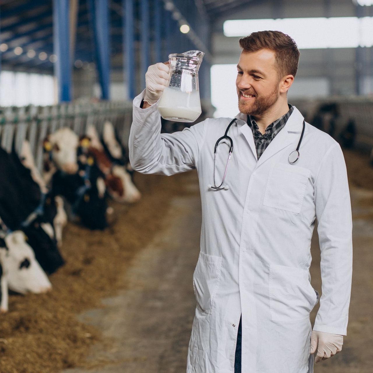 A vet is holding a pitcher of milk to check.