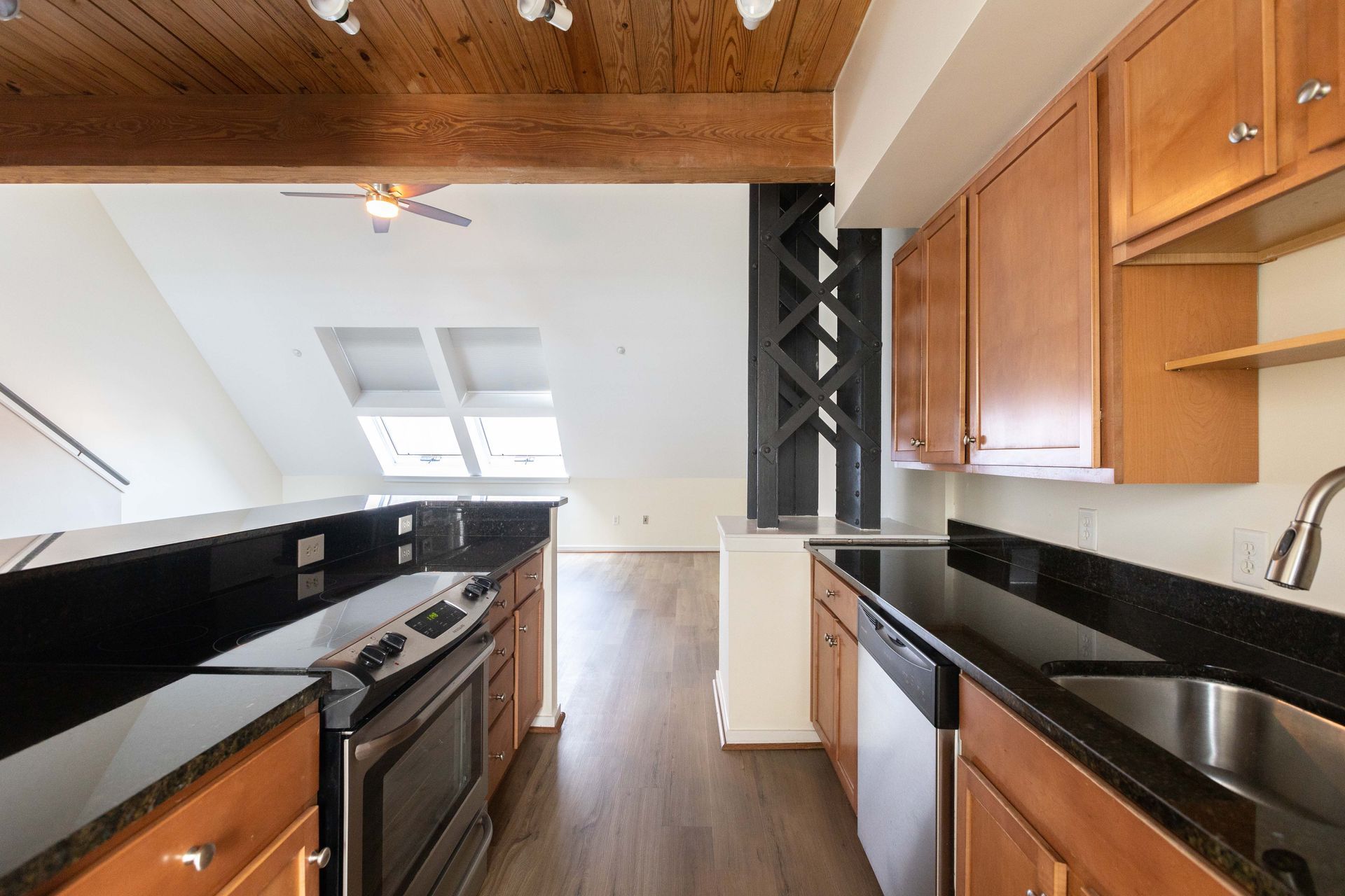 a kitchen with wooden cabinets and black counter tops