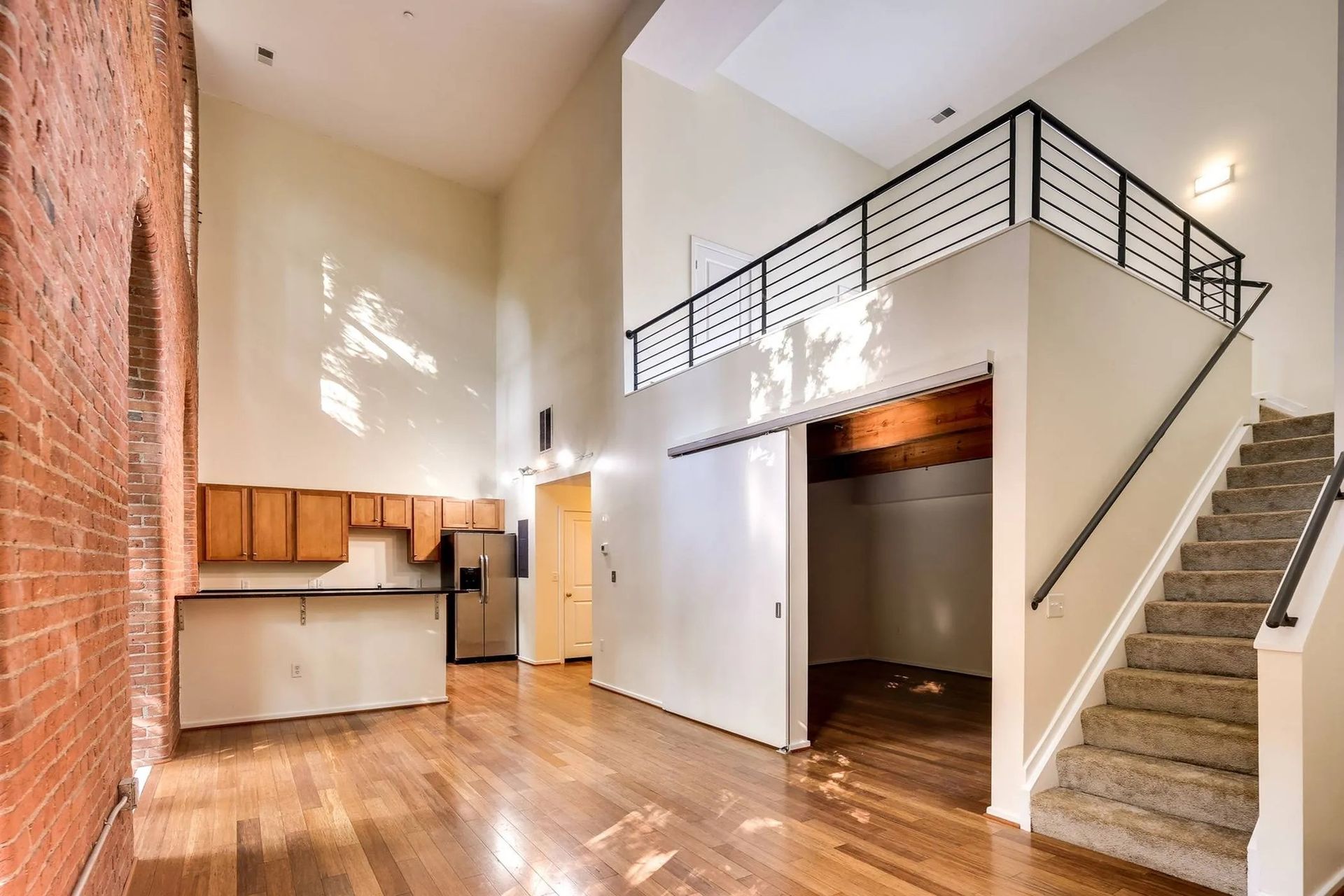 an empty apartment with stairs leading up to the second floor