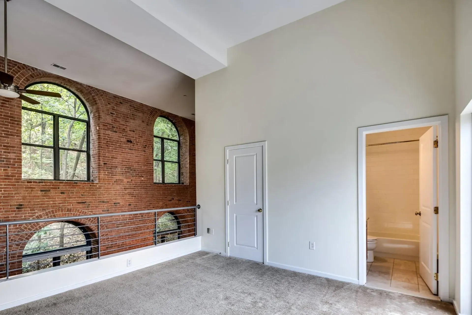 an empty room with a brick wall and a ceiling fan .