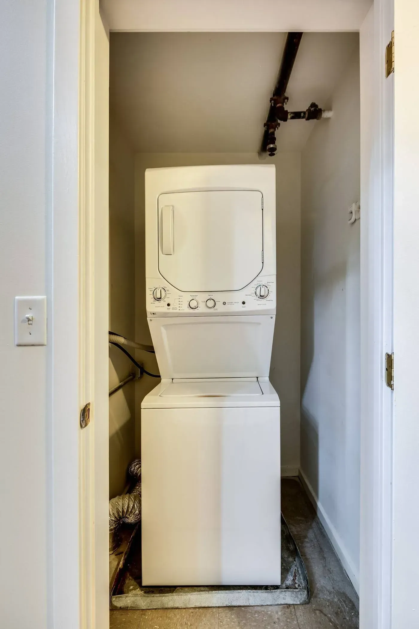 a washer and dryer are stacked on top of each other in a closet .