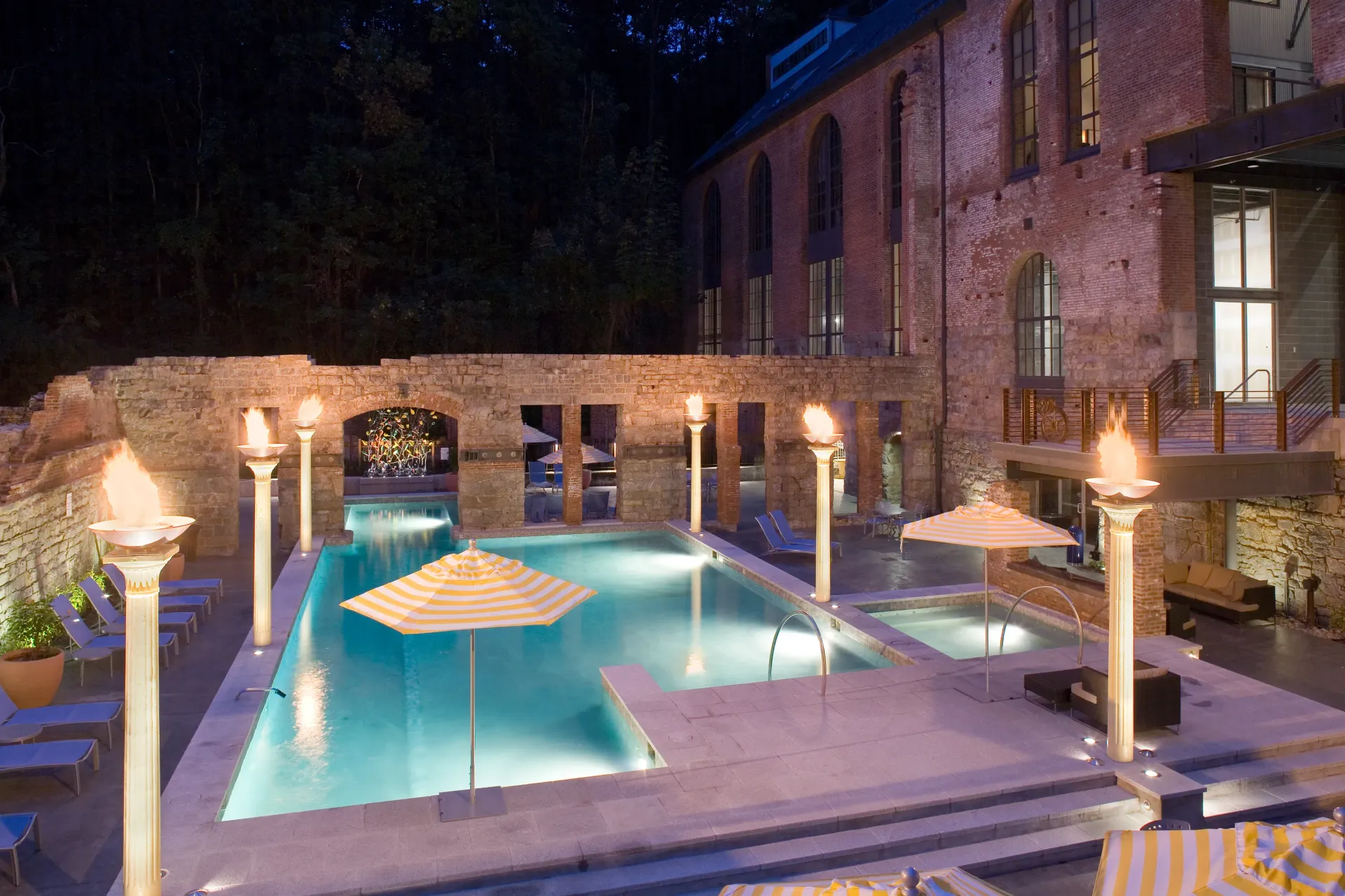 a large swimming pool is lit up at night