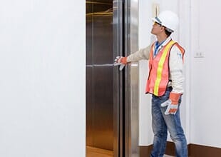 A Man Fixing Elevator Button — Elevator in Saint Paul, MN