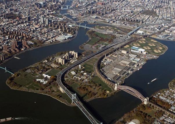 Aerial view of New York City's Randalls and Wards Islands with bridges, waterways, buildings, and fields.
