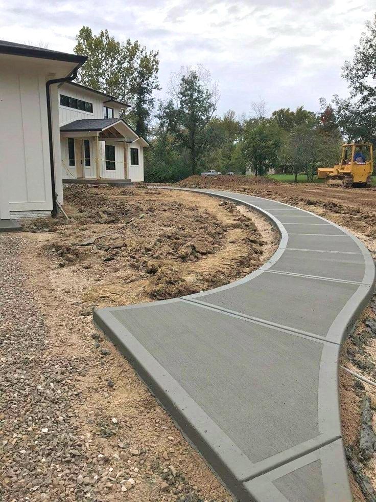 A stone walkway with concrete steps leading up to a house