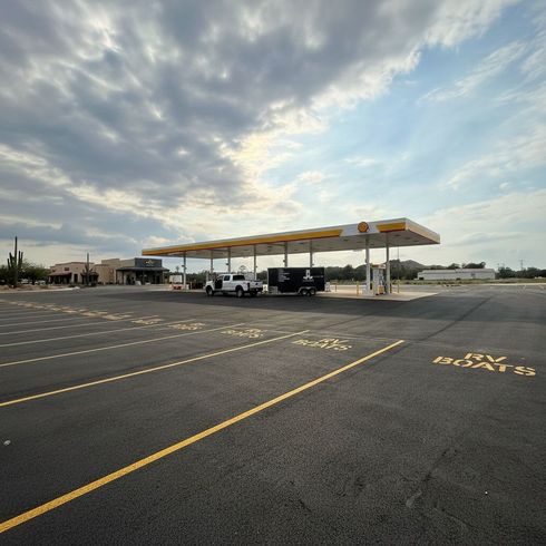 Professional parking lot striping at a gas station with clear yellow lines and numbered spaces