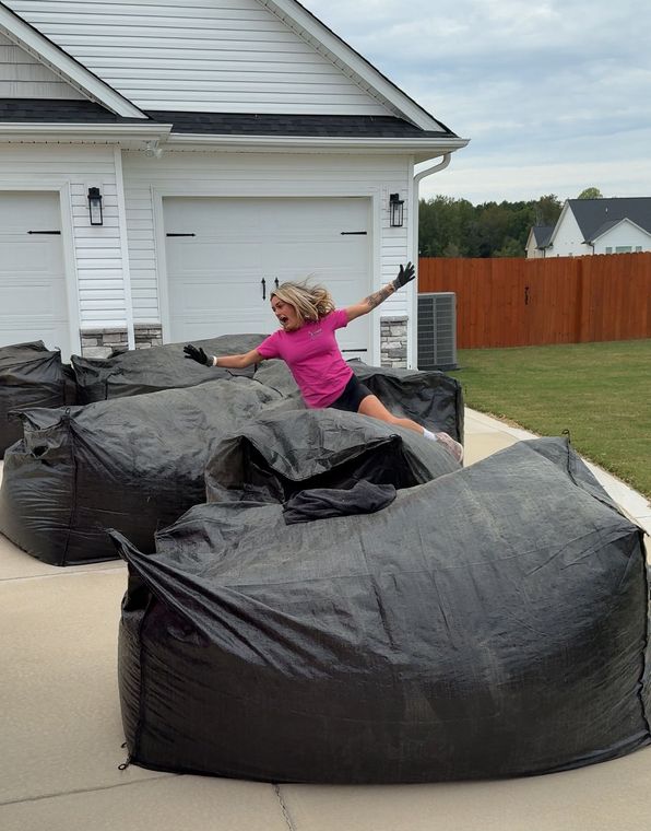 A group of women in pink tank tops are posing for a picture.