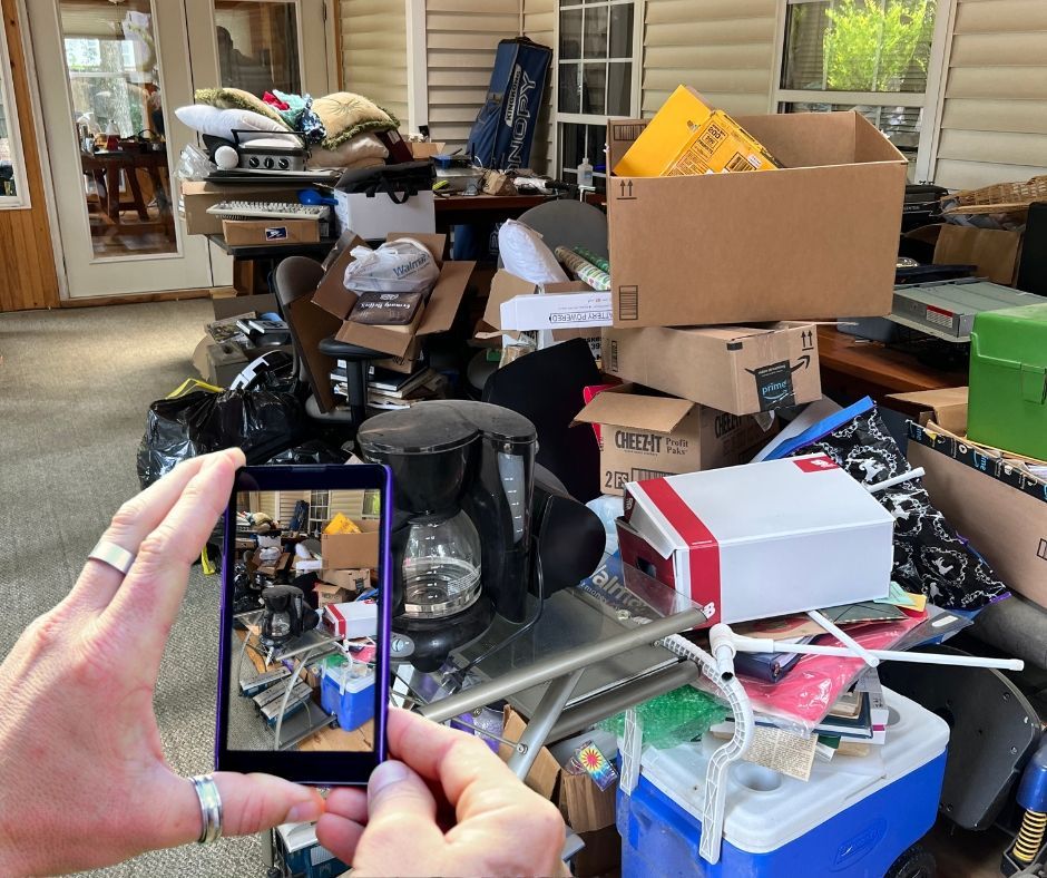 A person is taking a picture of a messy room with a cell phone