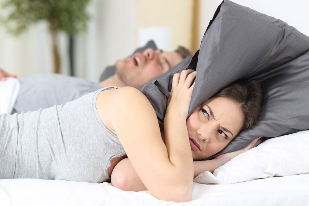 Man Snoring While His Wife Covering Ears With Pillow — Marriage Counselling in Dubbo, NSW