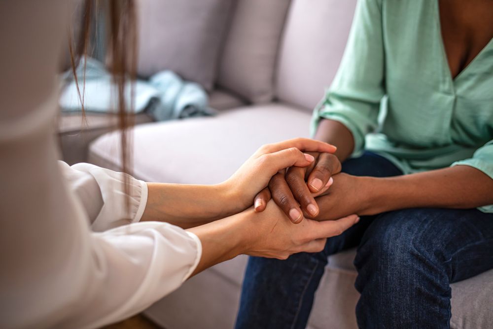 Psychologist Hold Hands Of Girl — Family Counselling in Dubbo, NSW