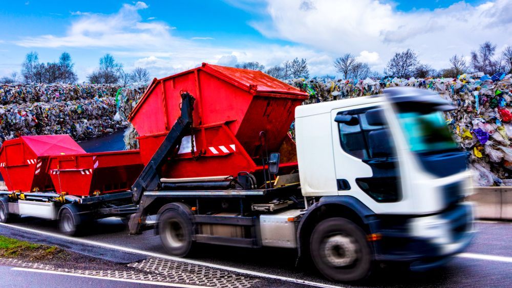 Red Dumpster Truck Transporting Two Large Red Containers on a Road — Red E Bins In Laurieton, NSW
