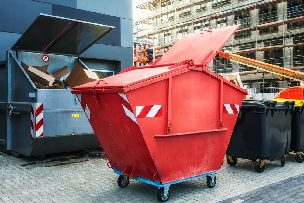 Red Waste Container With Lid Open, Next to a Large Waste Truck — Red e Bins in Lake Cathie, NSW