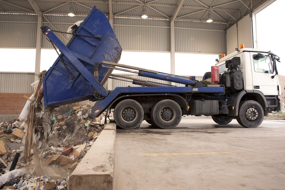 Blue Dumpster Truck Dumping Trash at a Waste Facility — Red E Bins In Wauchope, NSW