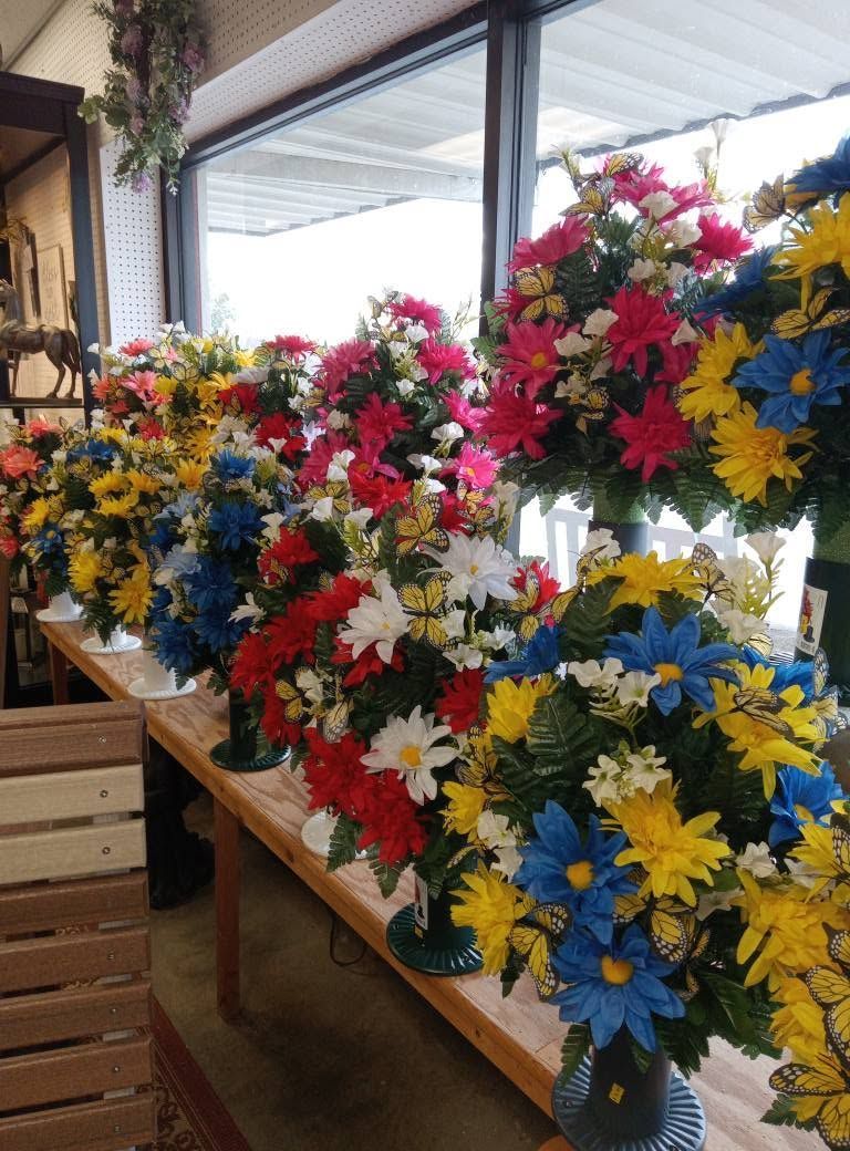 A row of vases filled with red yellow and blue flowers