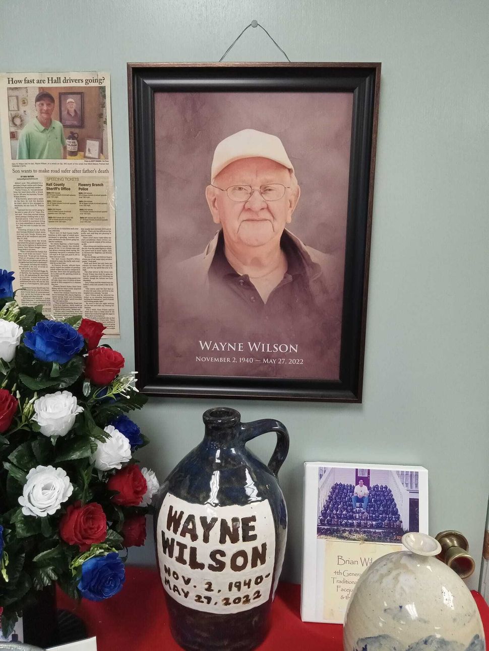 A picture of wayne wilson hangs above a pitcher