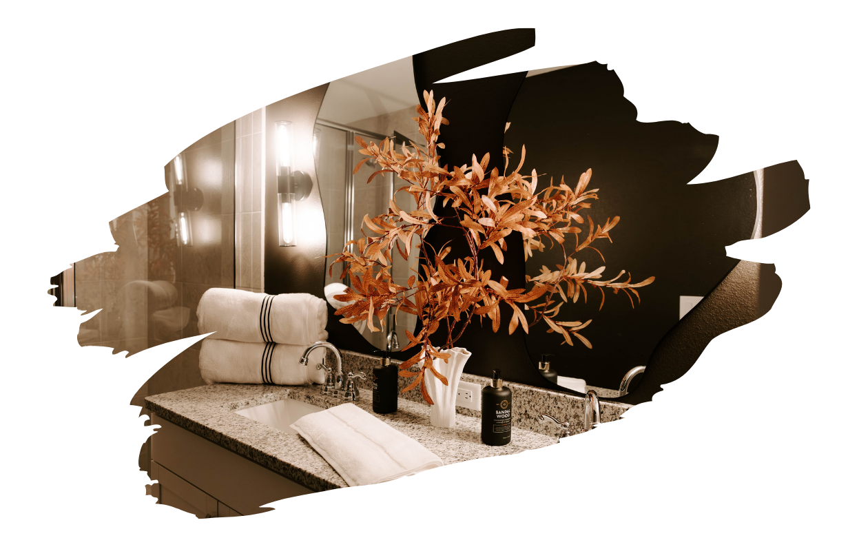 Bathroom vanity with towels, floral arrangement, and mirror.