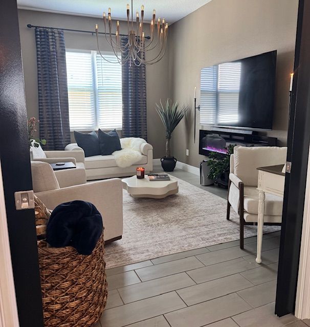 Kitchen with three woven pendant lights over an island with a white countertop and dark blue cabinets.