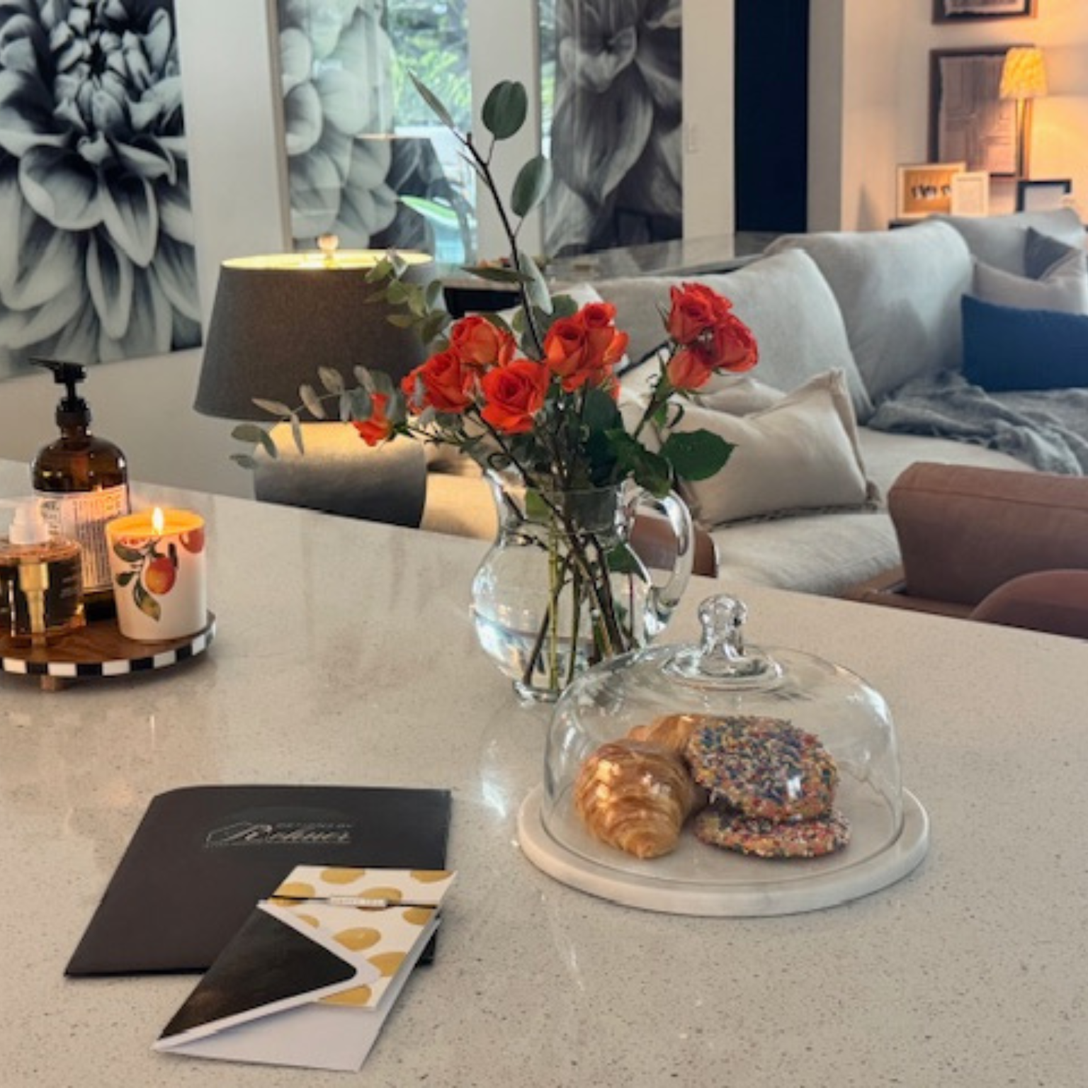 Kitchen with wood floors, island with woven bar stools, and a round table with a linen chair.