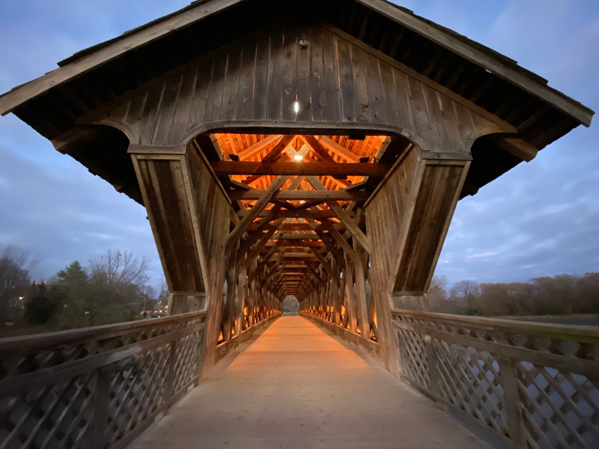Covered wooden bridge with warm interior lighting.