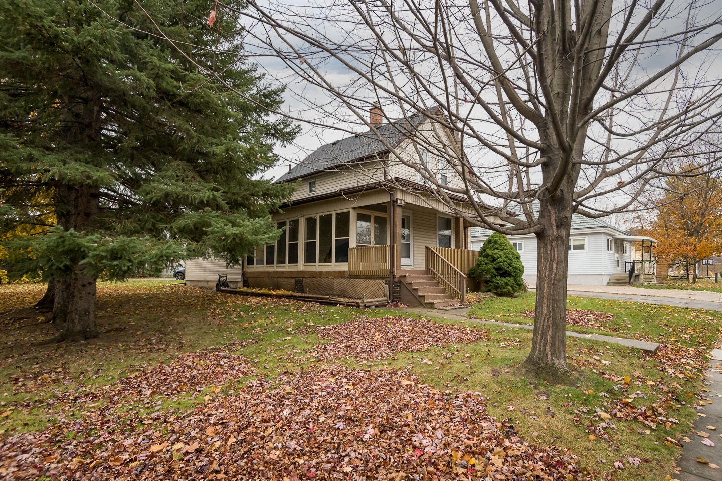 30 robert street, Milton, Ontario, a house with a porch and stairs is surrounded by trees and leaves