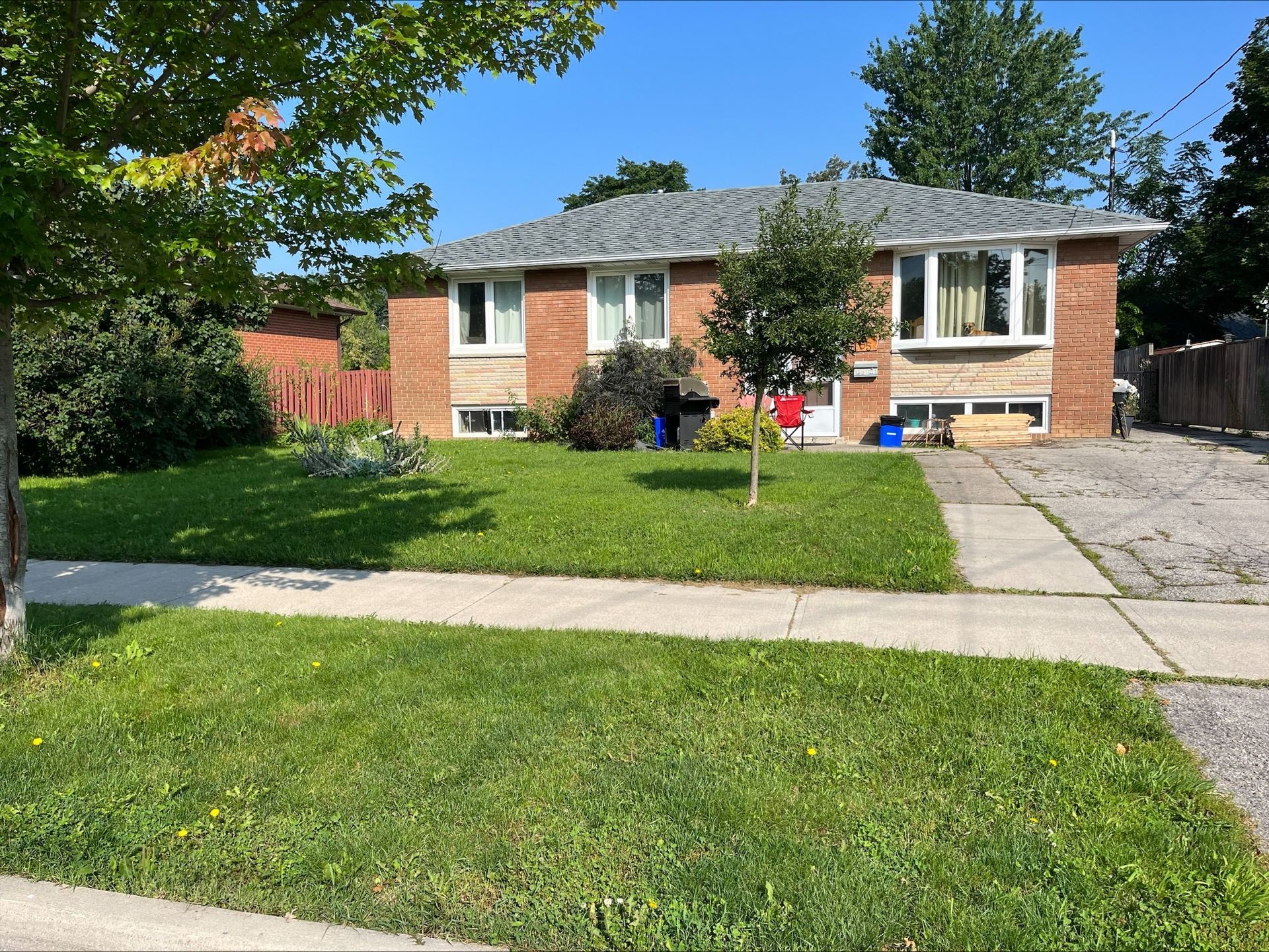 95 Heslop Road Lower | Milton, Ontario brick house with a gray roof and a lush green lawn