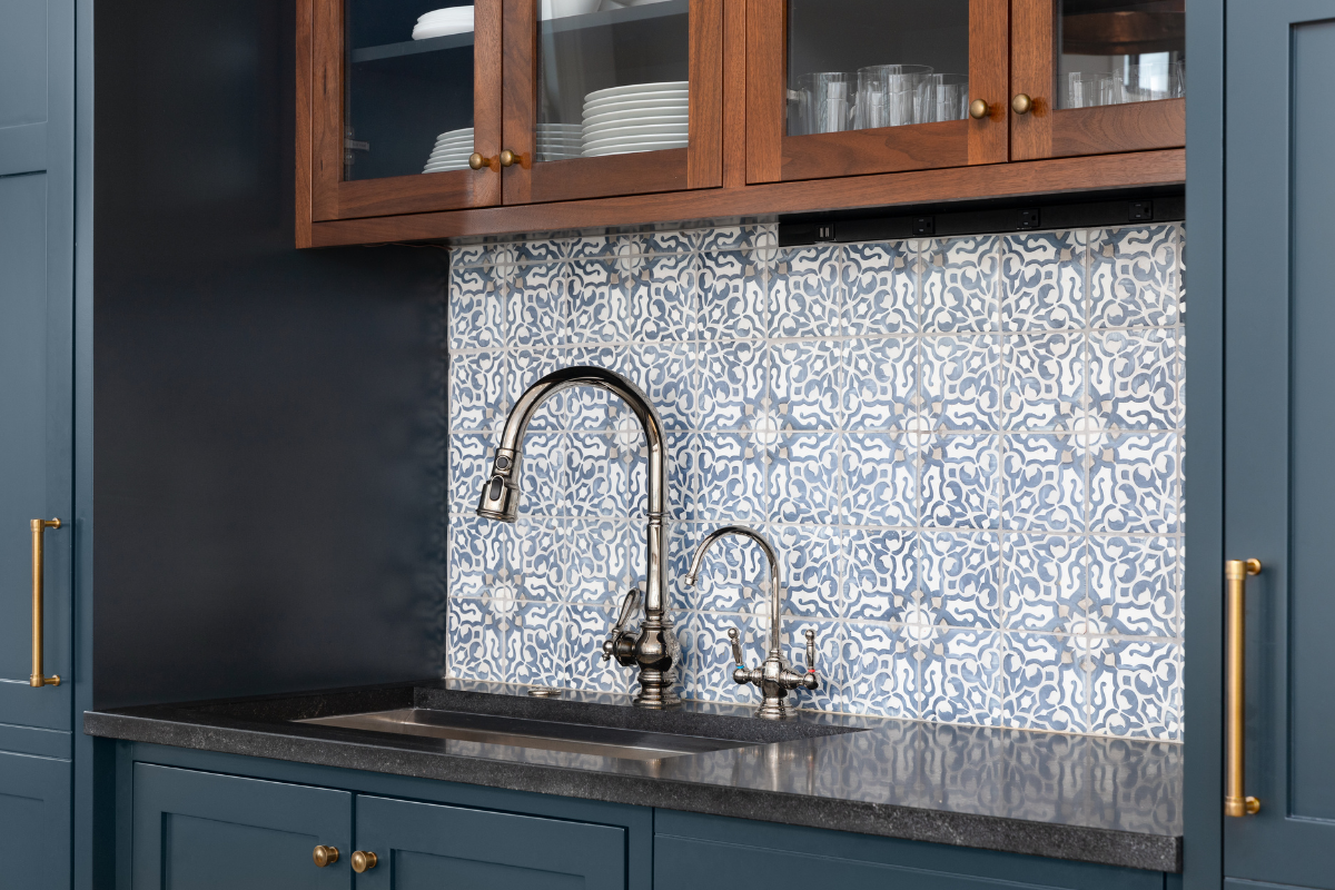 A kitchen with blue cabinets and a sink with a faucet.