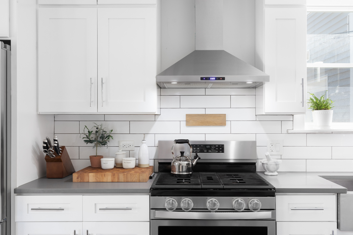 A kitchen with stainless steel appliances and white cabinets.