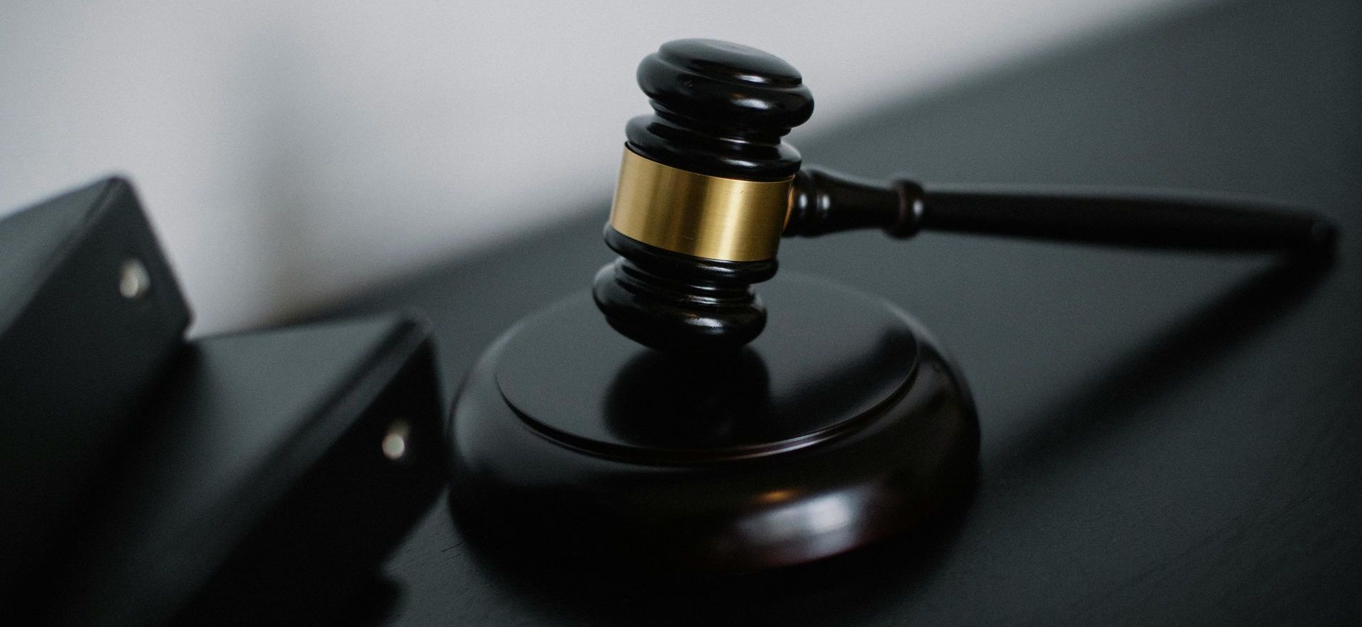 A judge 's gavel is sitting on top of a black table.