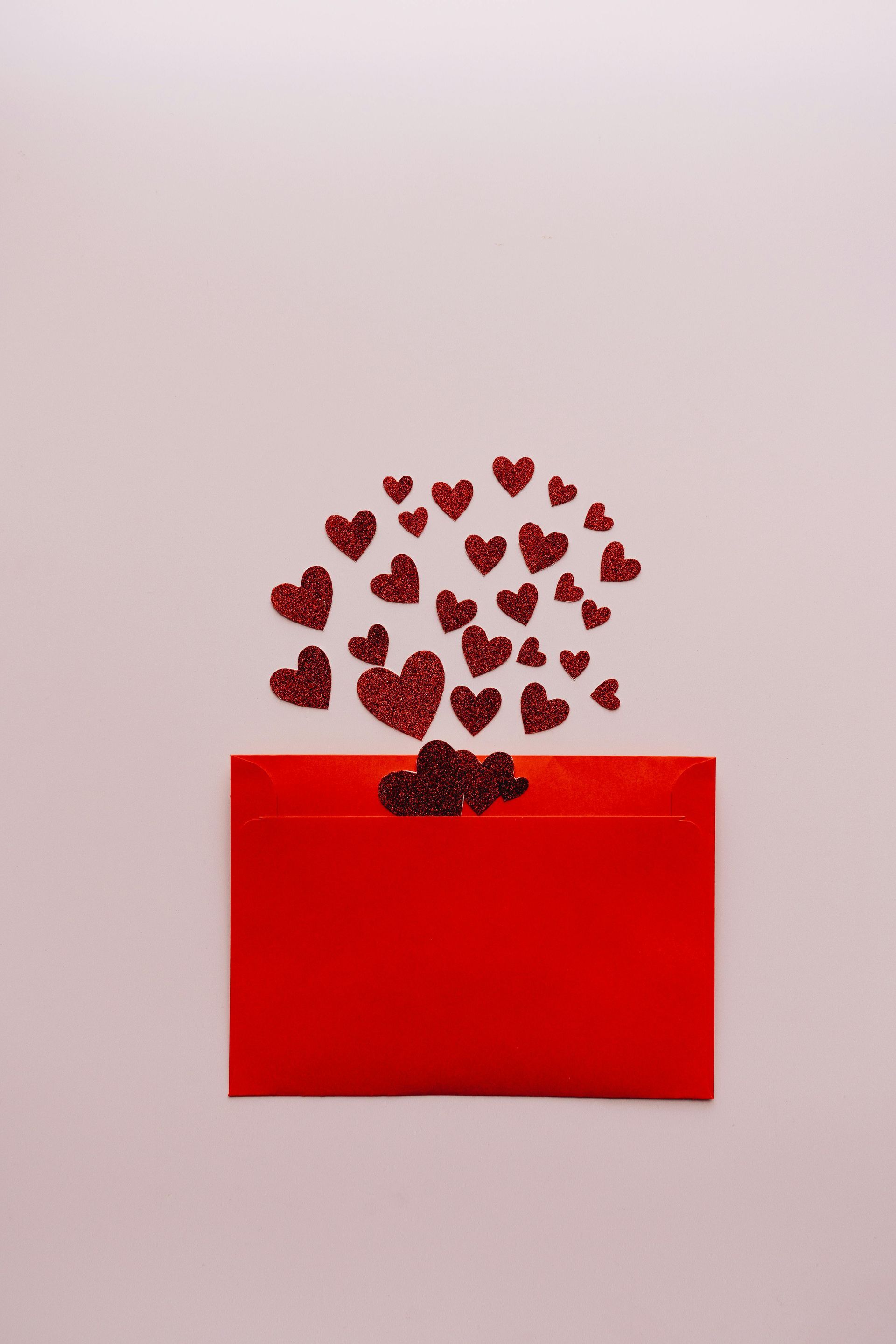 Red envelope with glitter hearts spilling out.