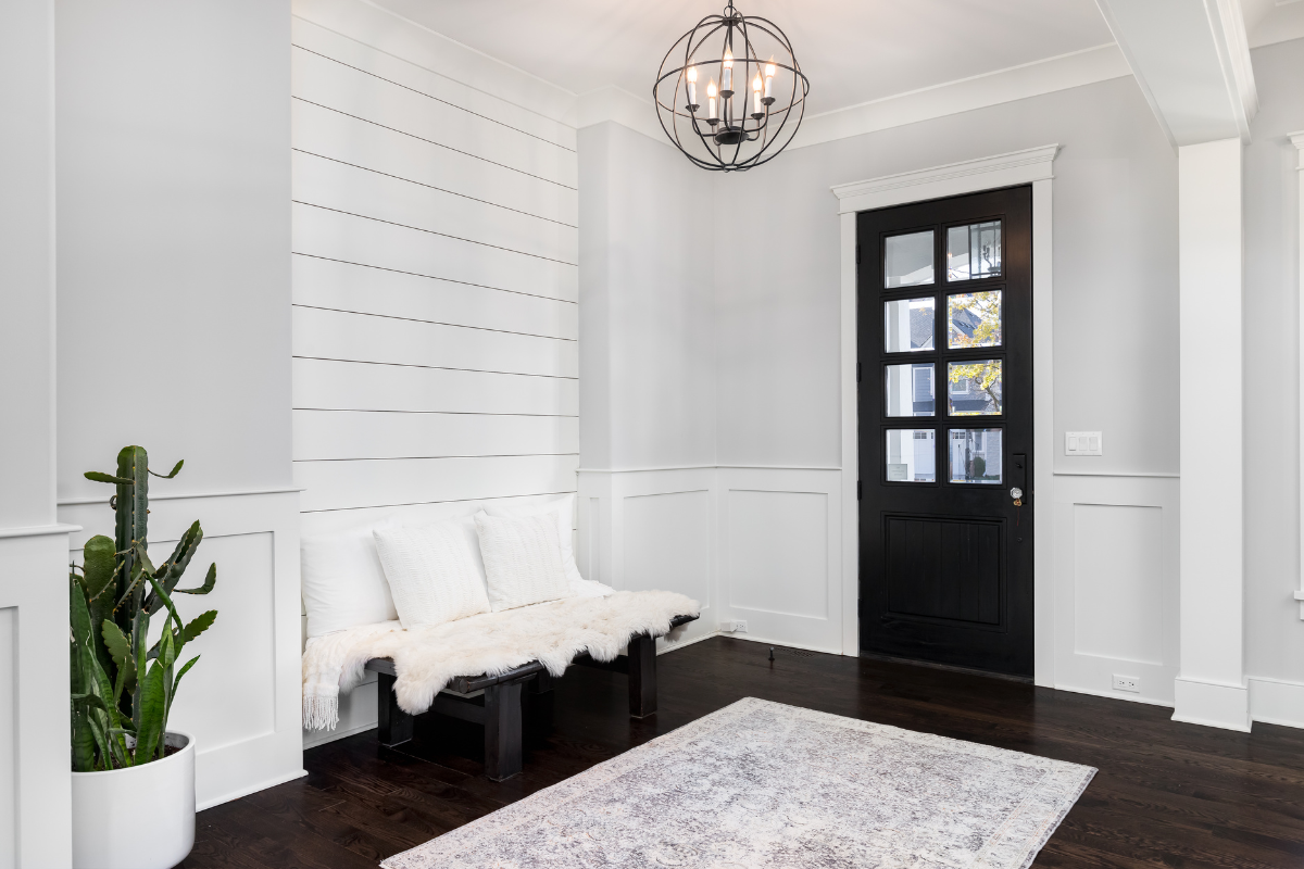 A living room with a black door and a couch.