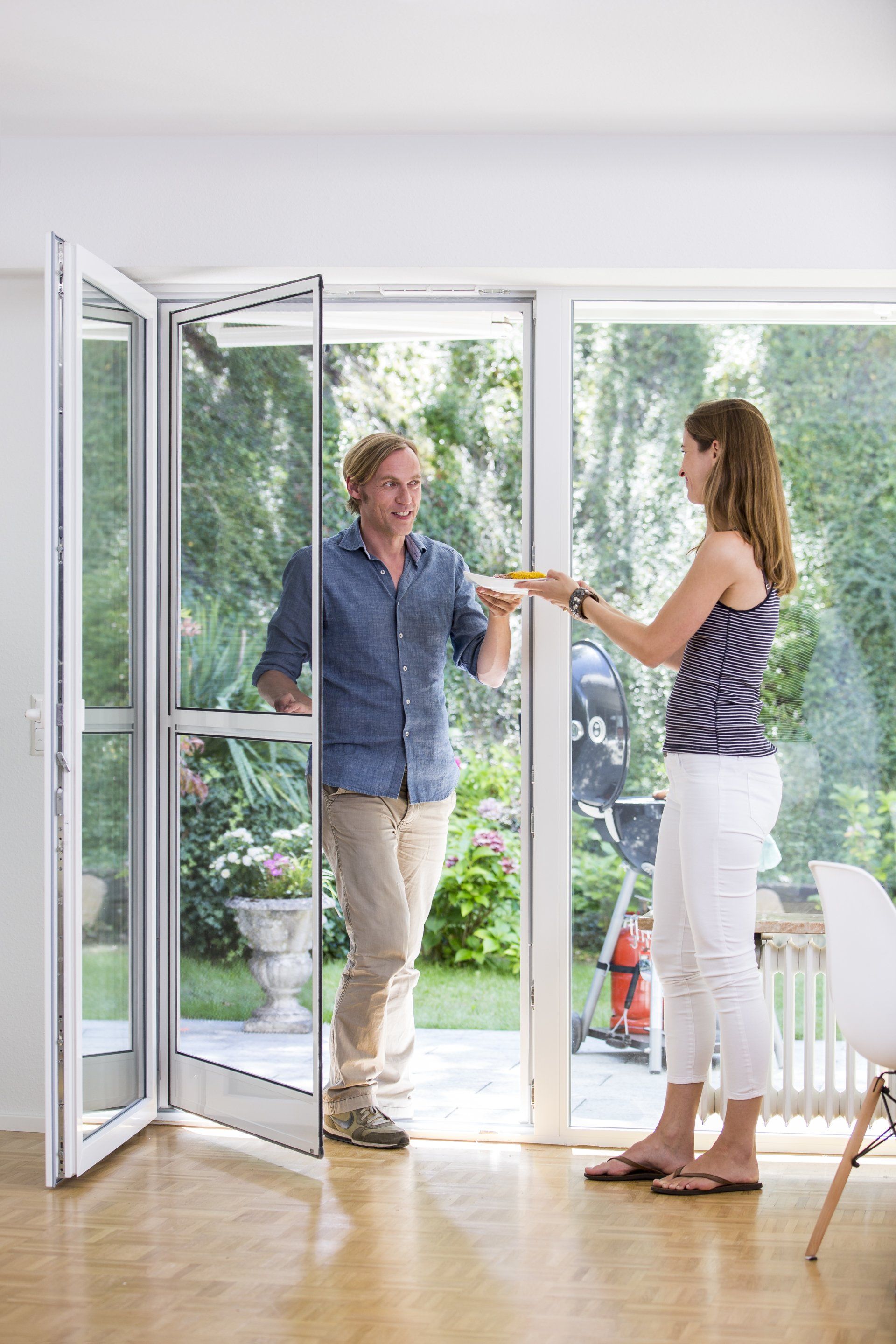 Ein Mann und eine Frau stehen vor einer Glasschiebetür.