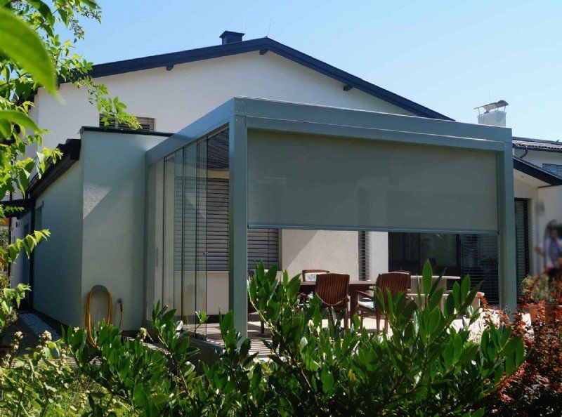 Ein weißes Haus mit einer Pergola davor