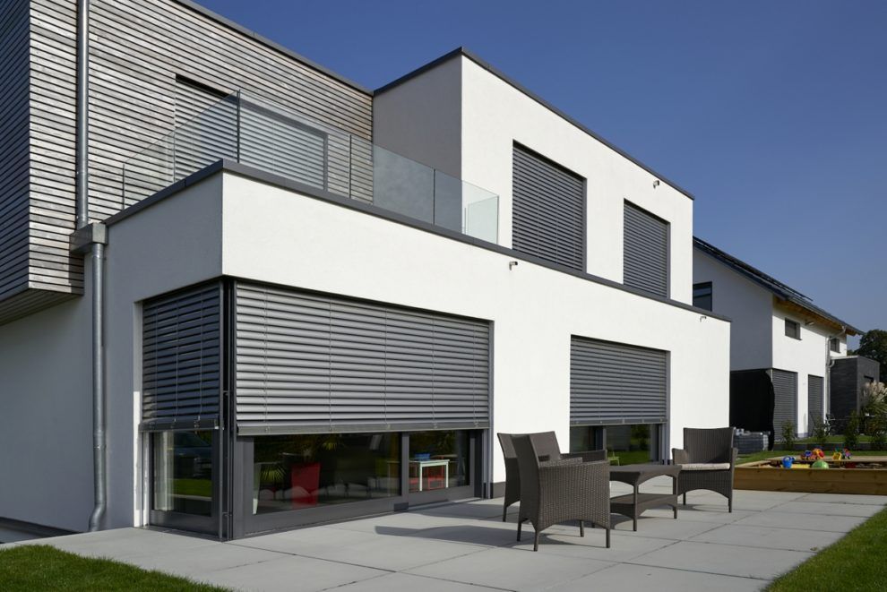 Ein großes weißes Haus mit einer Terrasse davor