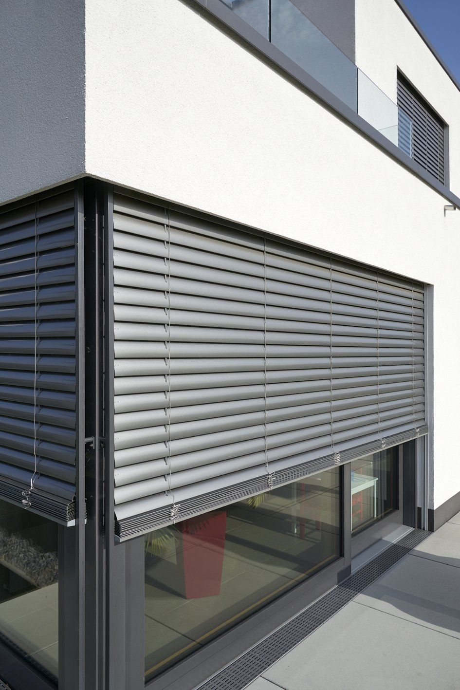 Ein Haus mit einem großen Fenster mit Jalousie.