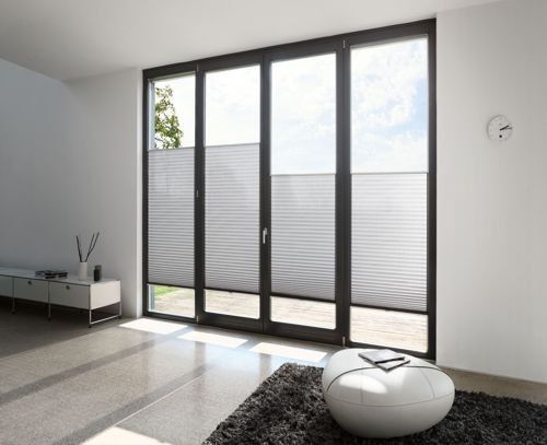 Ein Wohnzimmer mit einem großen Fenster und einer Uhr an der Wand.