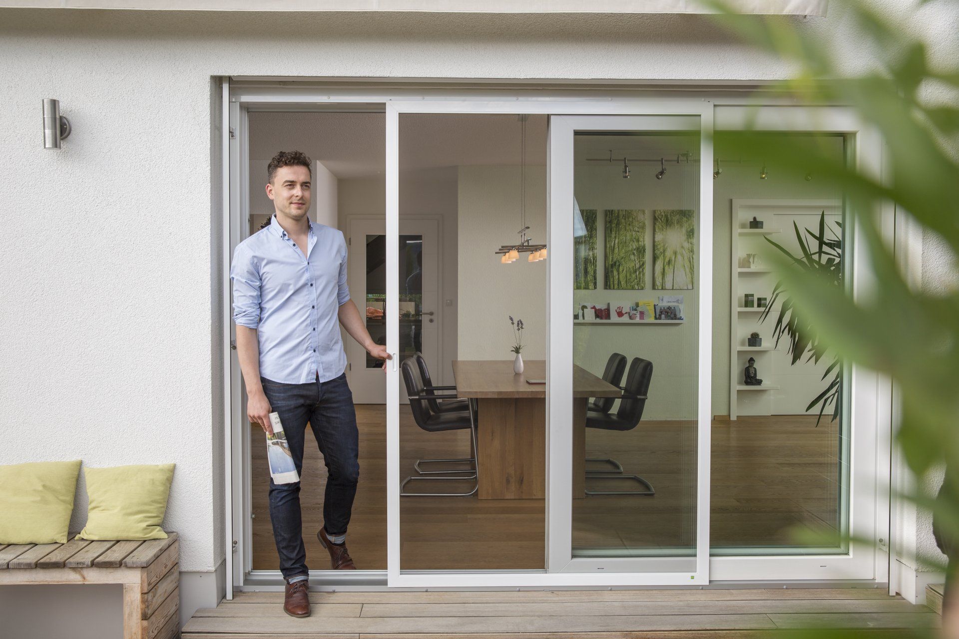 Ein Mann steht vor einer Glasschiebetür.