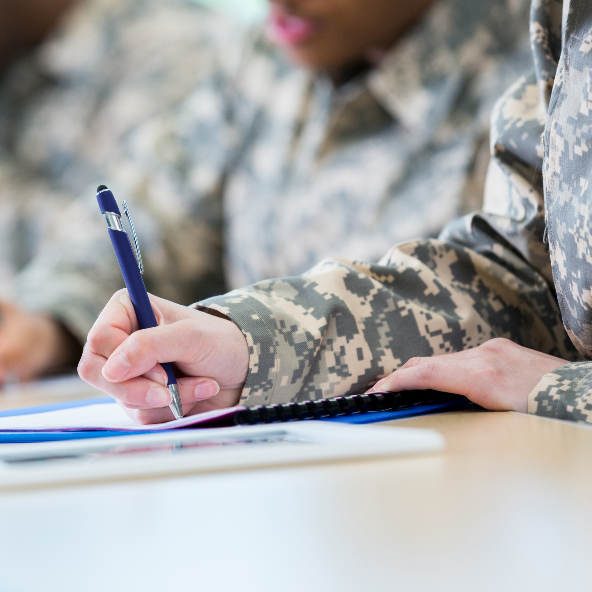 A veteran writing on a piece of paper with a pen.