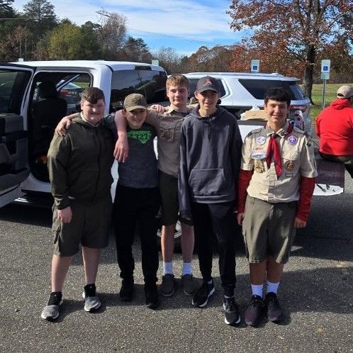 A group of young men are posing for a picture in front of a white van