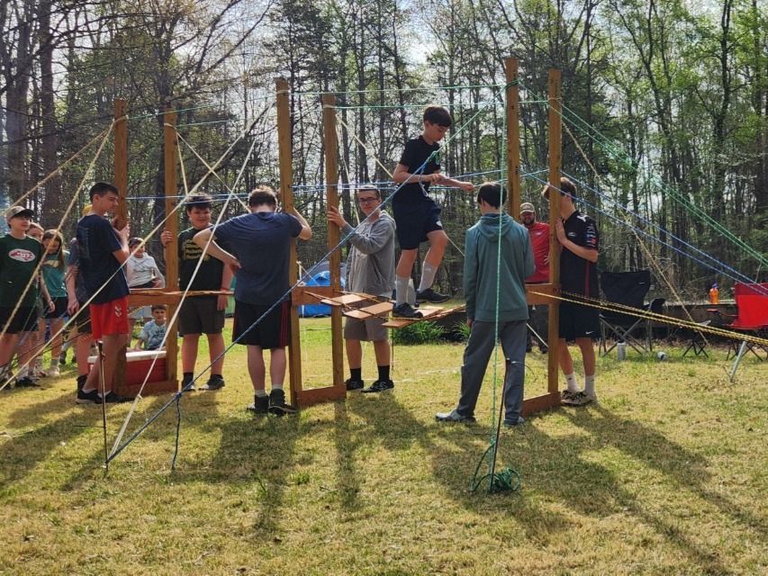 Scouts build a rope bridge, learning knots along the way. 