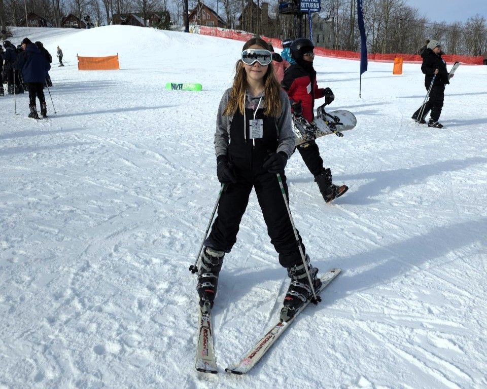 A woman is skiing down a snow covered slope