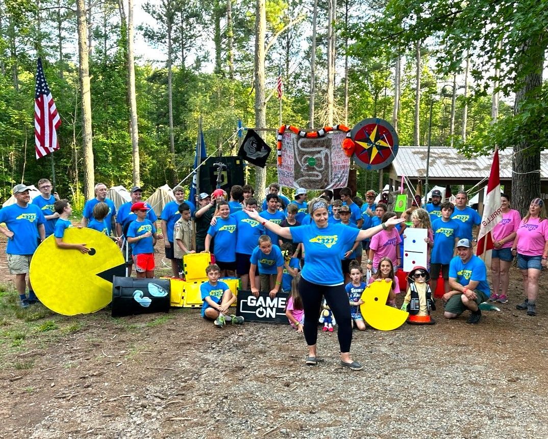 A group of people are posing for a picture with giant pac man toys.