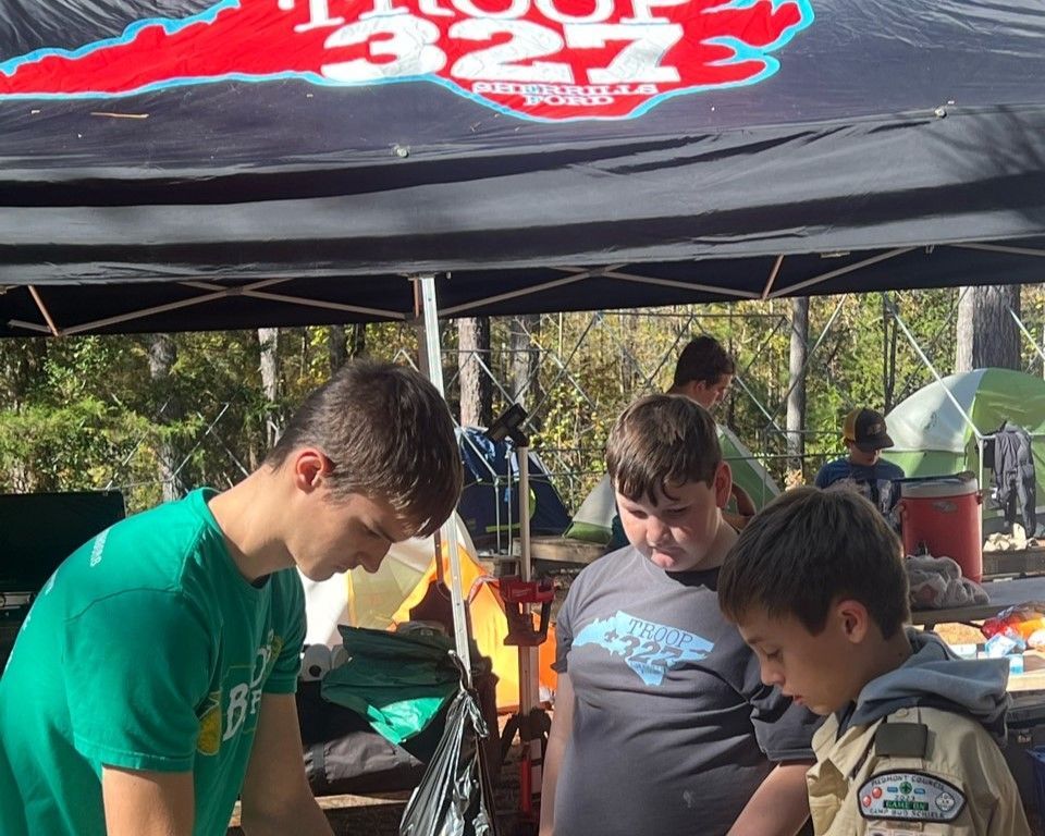 A group of young boys are standing under a tent with the number 322 on it