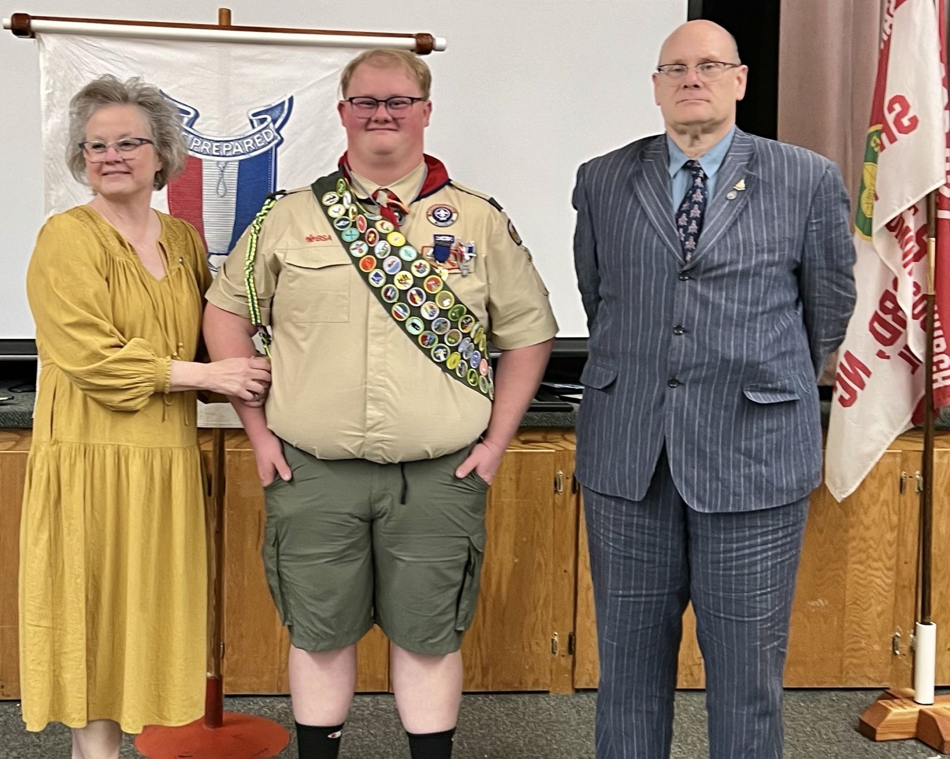 A group of people standing next to each other in front of a flag.
