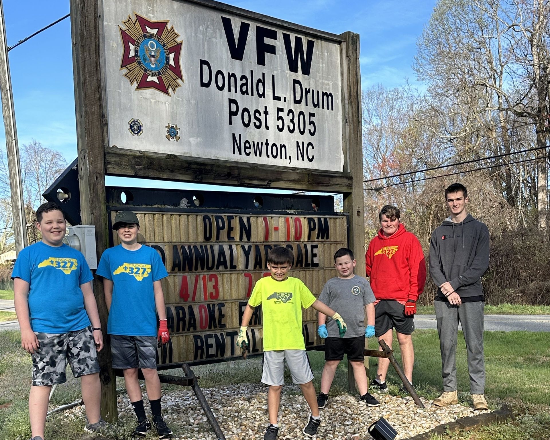 A group of young men are standing in front of a sign that says vfw